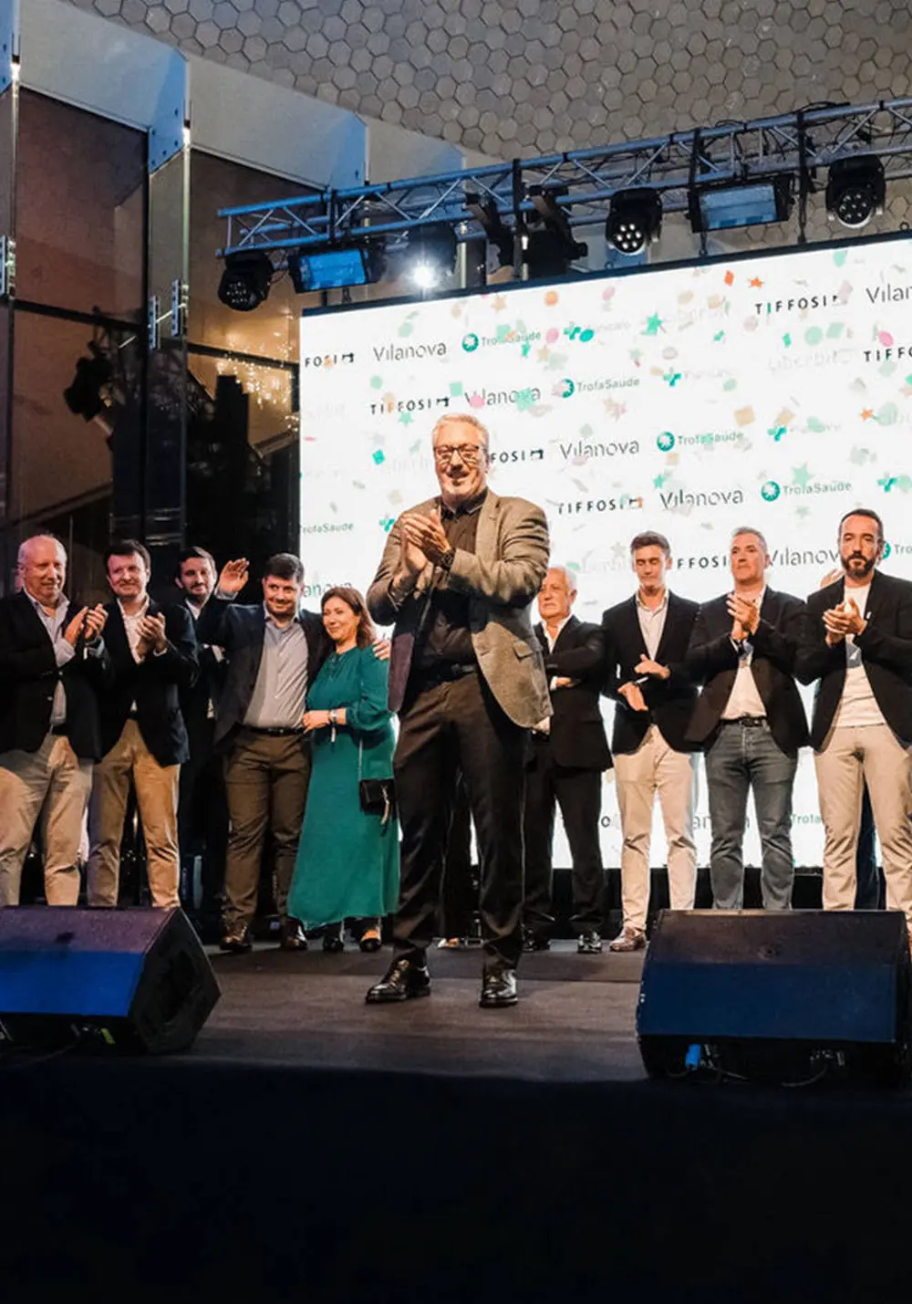 Homem a bater palmas com pessoas atrás