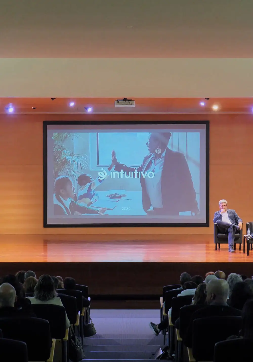 auditório com tela e pessoas a ver